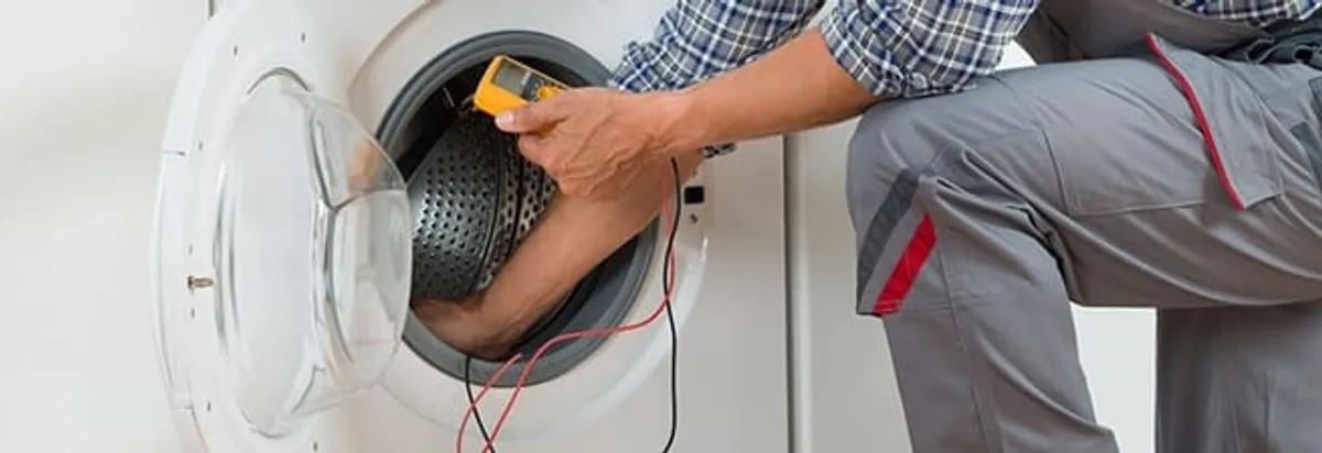 Dryer repair technician inspecting and repairing a clothes dryer in Fort Lauderdale, FL