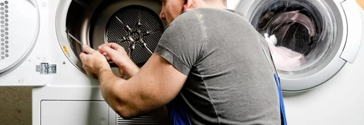 Dryer repair technician fixing a clothes dryer drum in Fort Lauderdale, FL