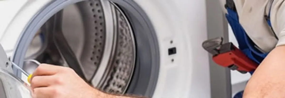 Appliance technician repairing a clothes dryer drum and internal parts in Fort Lauderdale, FL