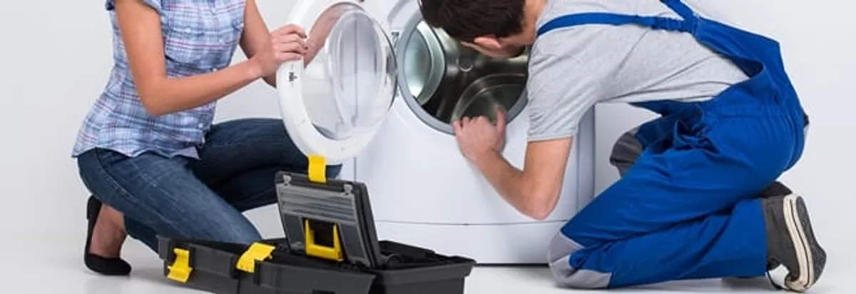 Washer repair technician inspecting a front-load washing machine with tools in Fort Lauderdale, FL