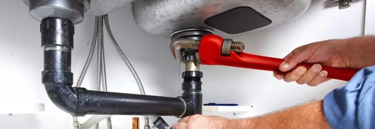 Garbage disposal repair technician tightening the sink drain and disposal connection in Fort Lauderdale, FL