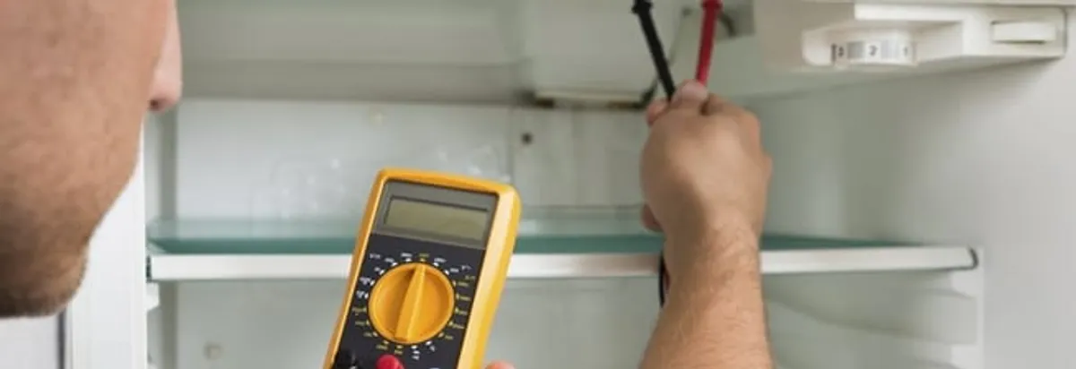 Refrigerator repair technician testing electrical components with a multimeter in Fort Lauderdale, FL