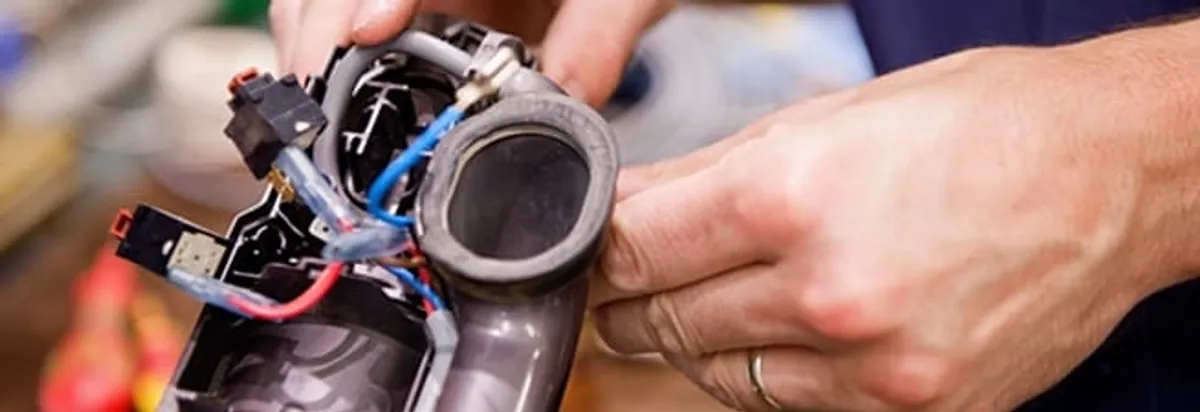 Vacuum repair technician reconnecting wiring and components in Fort Lauderdale, FL