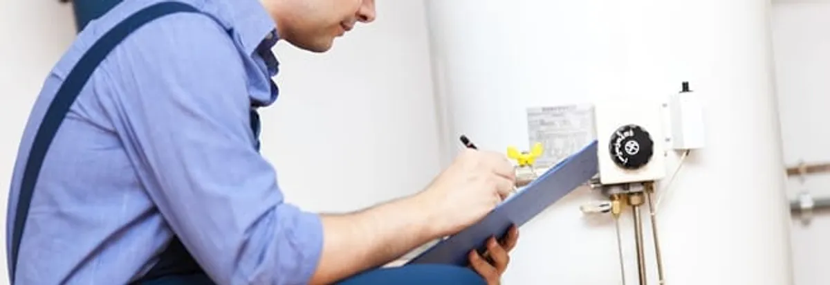 Water heater repair technician inspecting the unit and recording service notes in Fort Lauderdale, FL