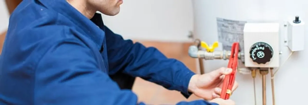 Water heater repair technician adjusting the temperature control and gas valve in Fort Lauderdale, FL